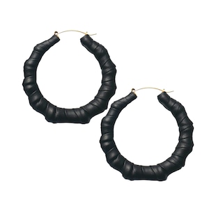 May include: A pair of large black hoop earrings with a twisted leather design. The earrings are made of a thick, durable material and have a gold-tone finish.