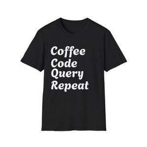 May include: Black t-shirt with the words "Coffee Code Query Repeat" in a white, stylized font. The text is stacked vertically, creating a simple yet eye-catching design. The shirt is a classic crew neck style.