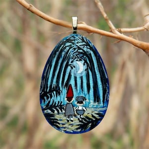 May include: An oval pendant featuring a hand-painted scene of two figures standing in a dark forest under a crescent moon. One figure wears a tall red hat and grey coat, while the other wears a dark cap and overalls. The pendant has a silver bail.