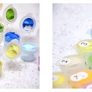 May include: A close-up of paint pots for a paint by numbers kit. The pots are labeled with numbers and contain different colors of acrylic paint. The paint pots are arranged in a grid pattern.