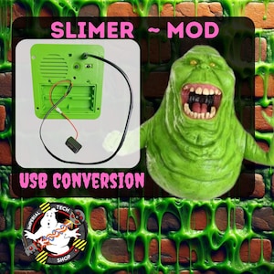 May include: A green Slimer toy with a wide open mouth and black teeth. The toy is on a brick wall background with green slime dripping down the wall. The text "SLIMER ~ MOD" is at the top of the image and "USB CONVERSION" is at the bottom. A logo for "Imperial Tech Shop" is in the lower left corner.