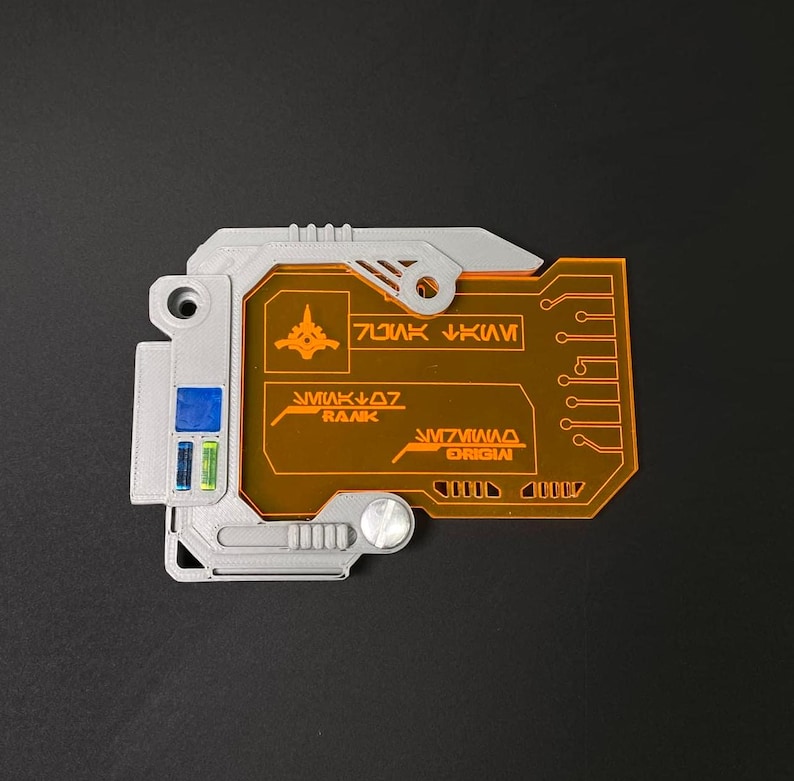 May include: A gray and orange plastic card with a circuit board design. The card has a small spaceship icon and the text "RANK 07" and "ORIGINAL" on it.