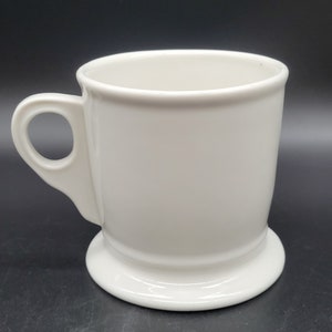 Puede incluir: Taza de afeitar de cer&aacute;mica blanca con asa y base ancha.