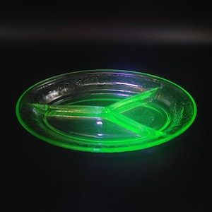 May include: A green glass divided serving dish with a textured surface. The dish is divided into three sections.