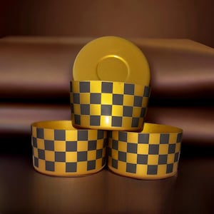 May include: Three gold and black checkered containers stacked on top of each other. The top container is a lid for the bottom two containers.