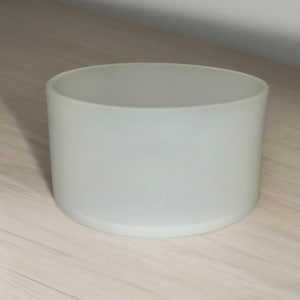 May include: A frosted white glass cylinder vase, perfect for displaying flowers or greenery.