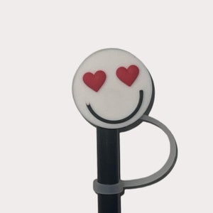 Op de afbeelding: Een zwart potlood met een witte smiley-gezichtstopper. De smiley heeft rode hartvormige ogen.