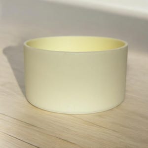 May include: A white silicone cup coaster, designed to protect surfaces from heat and condensation.