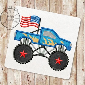 May include: Embroidered blue monster truck design with yellow flames, black wheels, and a red star. An American flag is attached. The design is on a white background.