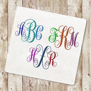 Op de afbeelding: Drie sets geborduurde monogramletters in verschillende kleuren: blauw, blauwgroen, groen, oranje, paars, roze en rood. De letters worden weergegeven op een witte achtergrond, met een houten oppervlak op de achtergrond.