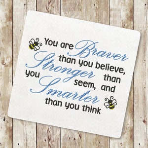 May include: White background with blue and black text that reads "You are Braver than you believe, Stronger than you seem, and Smarter than you think". Two yellow and black bee illustrations are on either side of the text.