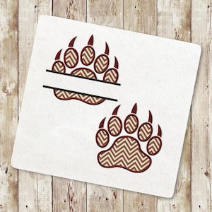May include: Two brown bear paw prints with a chevron pattern. The top paw print has a blank space for a name.