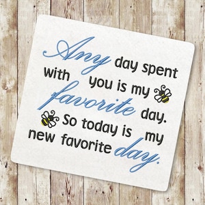 May include: A white card with blue and black text that reads "Any day spent with you is my favourite day. So today is my new favourite day."  Two small yellow and black bee illustrations are included.