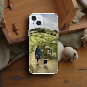 May include: White phone case with a rural landscape design. It depicts a person and a dog walking on a path, with sheep grazing in a green field. The person wears a red hat and blue coat. The dog is black and white.