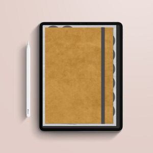 Puede incluir: Un planificador digital en una tableta, con una cubierta de color mostaza y una banda elástica negra. El planificador tiene pestañas negras y un lápiz óptico blanco. El fondo es rosa pálido.