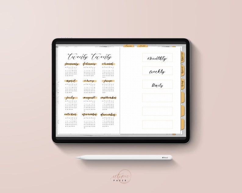 May include: A digital planner displayed on a tablet, featuring a 2020 calendar and organizational sections labeled "Monthly", "Weekly", and "Daily". The planner has a gold and white color scheme, with a stylus resting below. The text "utopie PAPER" is visible.