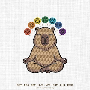 Op de afbeelding: Een borduurontwerp met een bruine capibara in een meditatieve zithouding met gesloten ogen. Boven de capibara bevinden zich zeven cirkelvormige chakrasymbolen in rood, oranje, geel, groen, lichtblauw, donkerblauw en paars. Tekst BarvnaEmbroidery.
