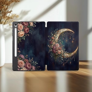May include: A black tablet case with a floral design and a crescent moon illustration. The case features a dark blue background with roses in shades of pink and cream. The open case reveals the interior design.