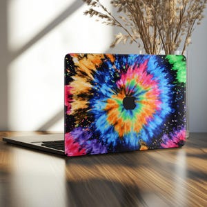 May include: A laptop with a colorful tie-dye design on the lid. The design features a spiral of vibrant colors including blue, orange, yellow, green, and purple, set against a black background. The Apple logo is visible.