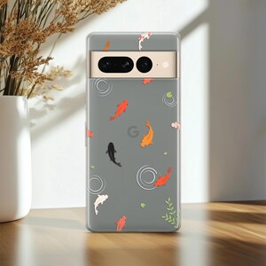 May include: A clear phone case for a Google Pixel 7 Pro featuring a printed pattern of orange, black, and white koi fish swimming among white circular water ripples and small green lily pads, with a visible camera bar across the top section.