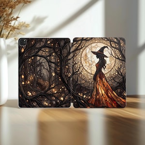 May include: A tablet case featuring a stained glass style illustration of a figure in a witch hat and long flowing dress standing before a large glowing moon, surrounded by dark intricate tree branches with small golden lights throughout.
