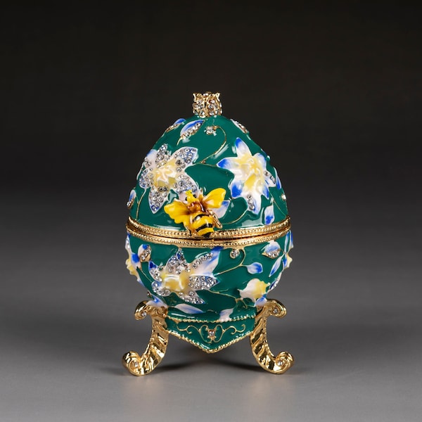 Faberge type egg with bee and flower green with floral pattern with Swarovski crystals opens to hold jewelry or trinkets. It is 3.75” tall