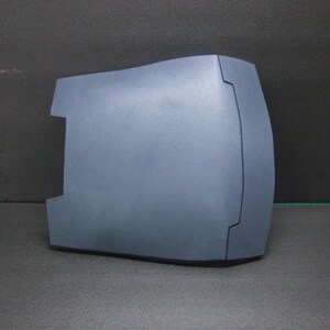 Puede incluir: Una pieza de pl&aacute;stico azul oscuro moldeada con una forma curva y un dise&ntilde;o texturizado en relieve. La pieza tiene un acabado liso y mate.