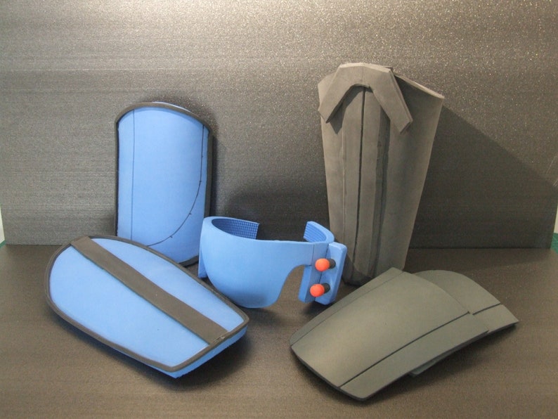 Op de afbeelding: Vijf schuimstukken voor het maken van cosplay of kostuums. Twee zijn blauw met zwarte bies, &eacute;&eacute;n is blauw met rode accenten en twee zijn zwart.