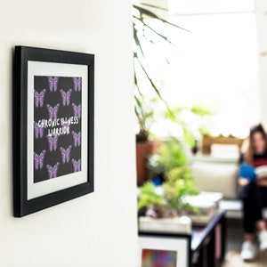 May include: A framed print with a black background and a pattern of purple butterflies. The text "Chronic Illness Warrior" is written in white letters.