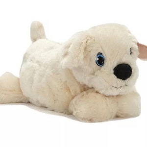 May include: A plush white dog toy with blue eyes and a black nose. The dog is lying on its belly with its paws outstretched.