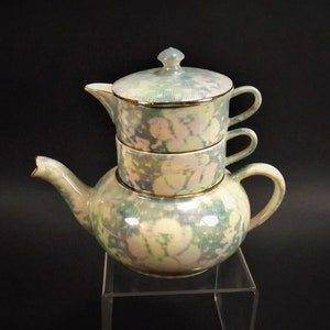 Puede incluir: Un juego de té vintage con un patrón floral verde y blanco. El juego incluye una tetera y dos tazas.