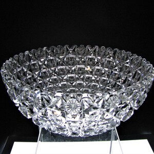 May include: A clear glass bowl with a cut glass design. The bowl is on a white surface.