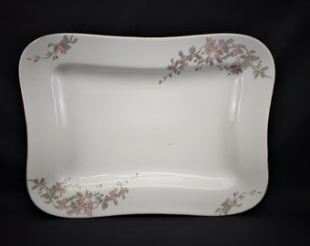 May include: A white rectangular serving platter with a floral design. The floral design is in shades of pink and gray and features small flowers and leaves.