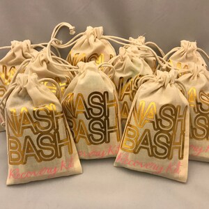 May include: Nine small, white cotton drawstring bags with gold lettering that reads "Wash Bash Recovery Kit".