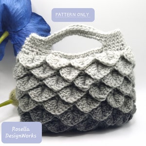 May include: A crochet bag with a gray and black ombre pattern. The bag has a handle and a scalloped edge. The text "PATTERN ONLY" is visible in the image.