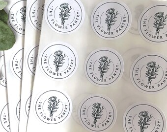 May include: A sheet of white stickers with black and white floral designs. Each sticker says "The Flower Pantry" in a black font.