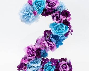 Decoração floral para aniversário com tema Frozen, número 1 e tema Elsa.