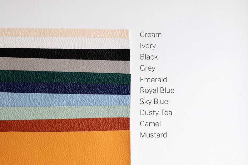 May include: A collection of 11 leather swatches in various colours, including cream, ivory, black, grey, emerald, royal blue, sky blue, dusty teal, camel, and mustard.