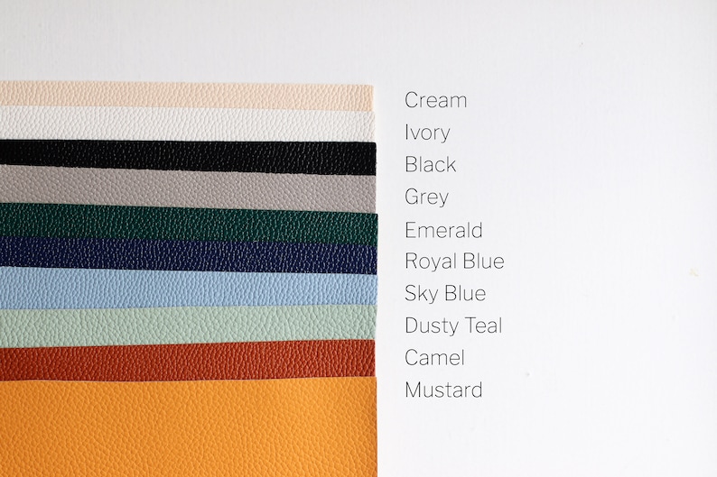 May include: A collection of 11 leather swatches in various colors, including cream, ivory, black, gray, emerald, royal blue, sky blue, dusty teal, camel, and mustard.