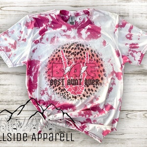 May include: Pink and white tie-dye t-shirt with a pink and black leopard print circle design. The circle design features a hand giving the peace sign and the text "BAE Best Aunt Ever".