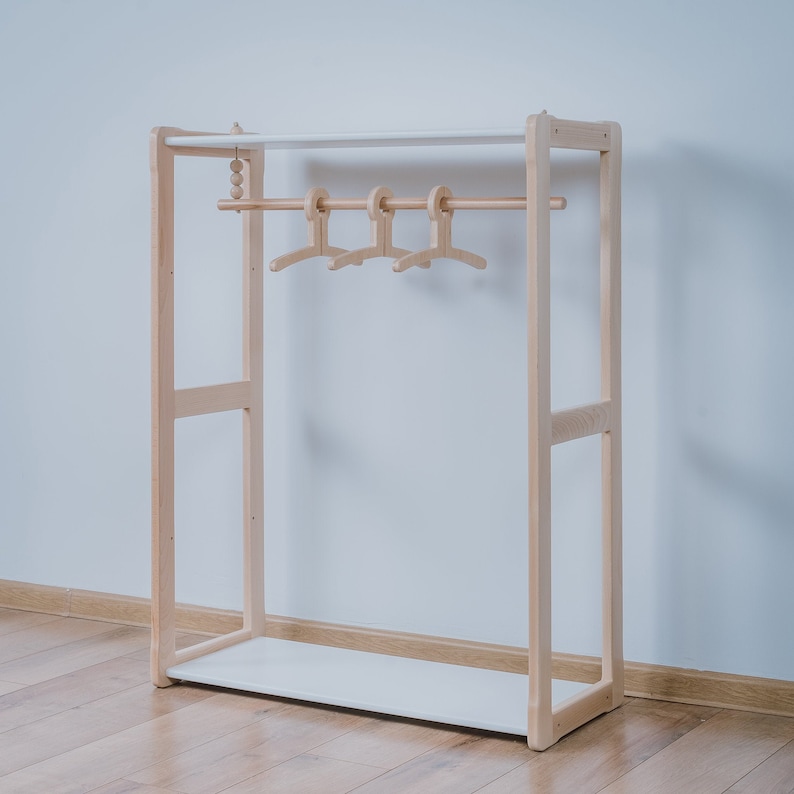 On the picture is a combination of our Montessori Type B clothing rack with our MAXI shelf. The wardrobe has a stylish hanger holder on the top. Our Maxi shelf has the same height and 4 compartments, where you can store other necessities.