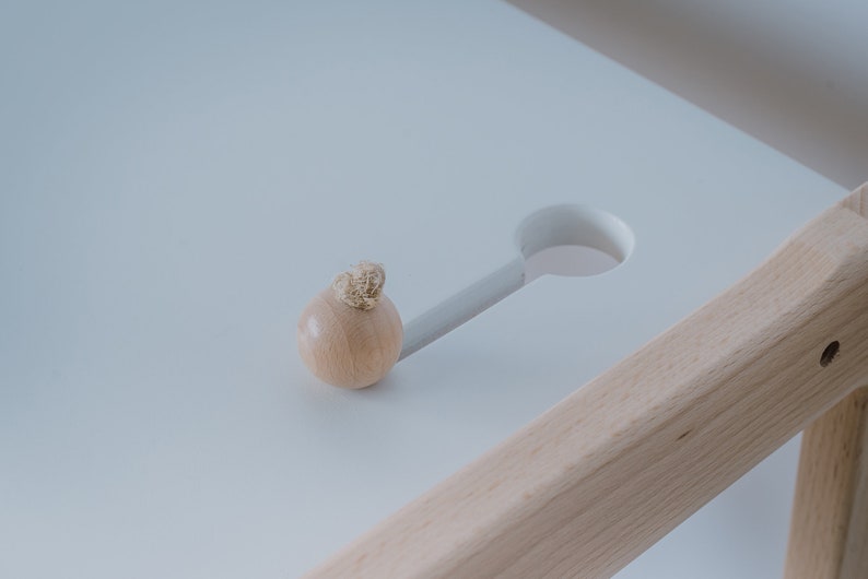 K&ouml;nnte beinhalten: Ein Holzgriff mit einem Seildetail sitzt auf einer wei&szlig;en Oberfl&auml;che mit einem Ausschnitt. Die Oberfl&auml;che ist Teil eines Holztisches.