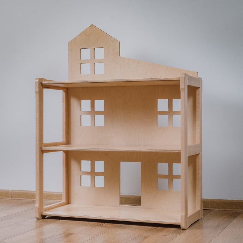 Puede incluir: Una casa de mu&ntilde;ecas de madera natural, con un techo en forma de casa y varias ventanas cuadradas. La casa de mu&ntilde;ecas tiene dos estantes y una puerta en el nivel inferior. El juguete est&aacute; dise&ntilde;ado para ni&ntilde;os.