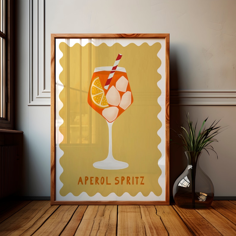 Peut inclure: Une affiche de style vintage avec un fond jaune et une bordure blanche. L'affiche repr&eacute;sente un verre d'Aperol Spritz avec une tranche d'orange et des gla&ccedil;ons. Le texte "Aperol Spritz" est imprim&eacute; en noir en bas de l'affiche.