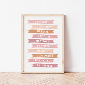 K&ouml;nnte beinhalten: Ein druckbarer Poster mit rosa und braunen Bannern, auf denen steht "Ich bin freundlich", "Ich bin ehrlich", "Ich bin mutig", "Ich bin klug", "Ich bin stark", "Ich bin einzigartig", "Ich bin geliebt", "Ich bin gewollt", "Ich bin fantastisch" und "Ich bin Harriet".
