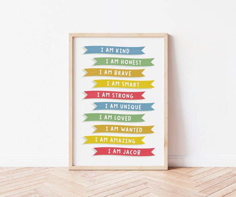 K&ouml;nnte beinhalten: Ein gerahmter Druck mit wei&szlig;em Hintergrund und bunten Bannern mit positiven Affirmationen. Der Text auf den Bannern lautet: "Ich bin freundlich", "Ich bin ehrlich", "Ich bin mutig", "Ich bin klug", "Ich bin stark", "Ich bin einzigartig", "Ich bin geliebt", "Ich bin gewollt", "Ich bin gro&szlig;artig", und "Ich bin Jacob".