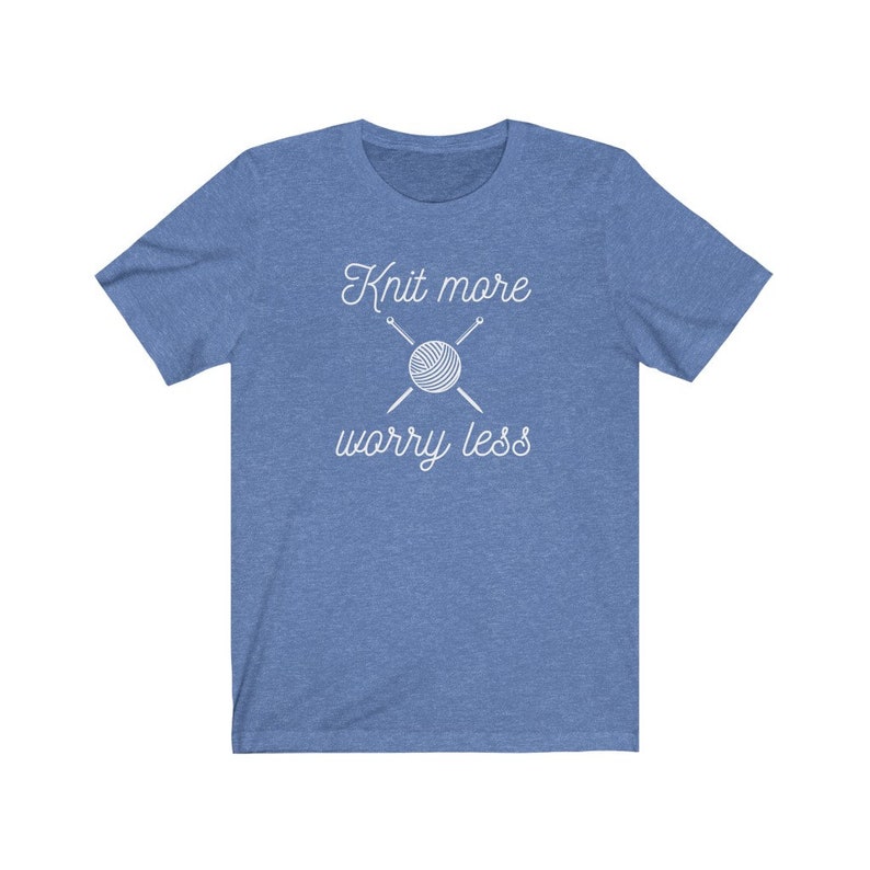 May include: A blue t-shirt with the text "Knit more worry less" in white. A white outline of a ball of yarn and knitting needles is above the text.
