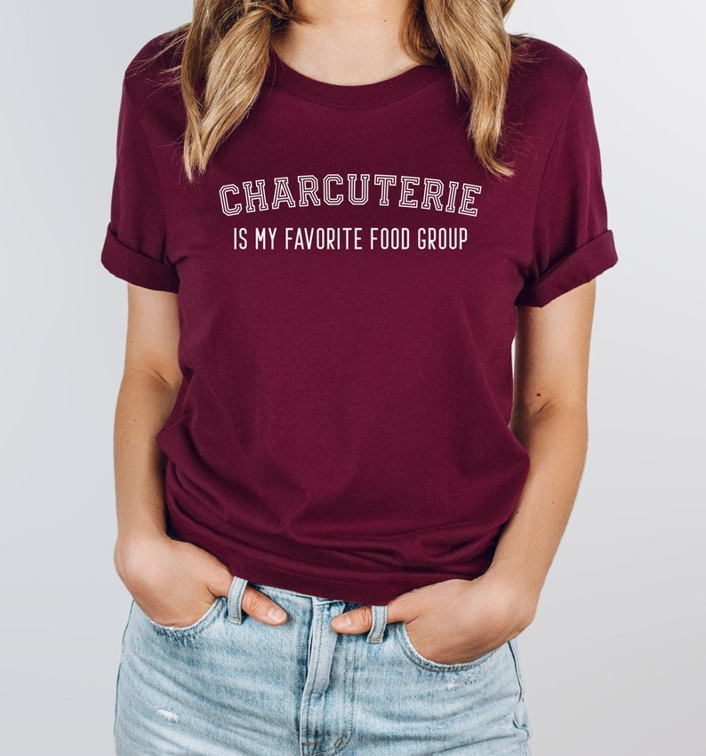Peut inclure: Un t-shirt bordeaux avec un texte blanc qui dit "CHARCUTERIE IS MY FAVORITE FOOD GROUP".