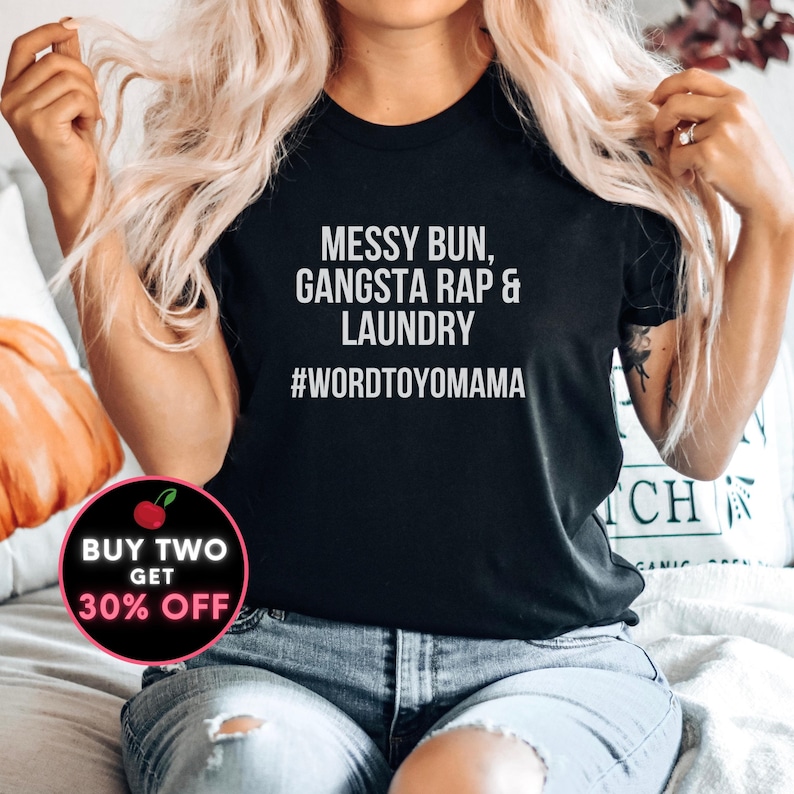 K&ouml;nnte beinhalten: Schwarzes T-Shirt mit Rundhalsausschnitt und dem wei&szlig;en Text "MESSY BUN, GANGSTA RAP & LAUNDRY #WORDTOYOMAMA". Ein runder Aufkleber mit dem Text "BUY TWO GET 30% OFF" befindet sich in der unteren linken Ecke.