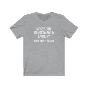 K&ouml;nnte beinhalten: Hellgraues T-Shirt mit wei&szlig;em Text "MESSY BUN, GANGSTA RAP & LAUNDRY" und dem Hashtag "#WORDTOYOMAMA". Das Shirt hat kurze &Auml;rmel und einen Rundhalsausschnitt.